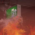 Fire burning with emergency exit sign in building