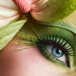 Woman eye with colorful make-up and long false eyelashes - gerber flower